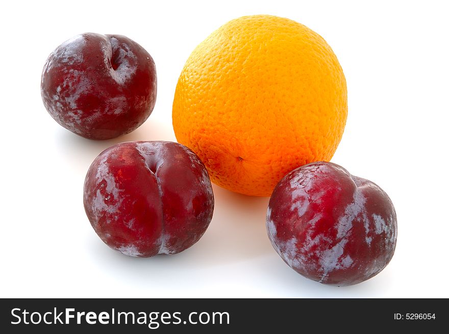 Three lilac plums and orange on overwhite background. Three lilac plums and orange on overwhite background.