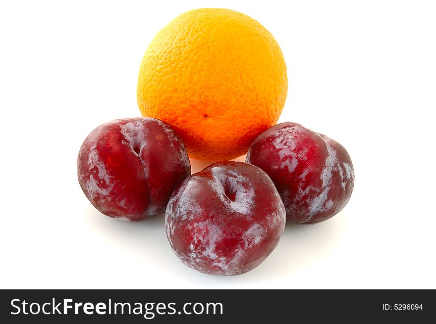 Three lilac plums and orange on overwhite background. Three lilac plums and orange on overwhite background.