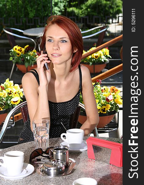 Young girl with mobile in open-air coffee