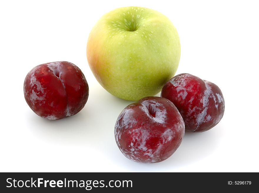 Three lilac plums and apple on overwhite background. Three lilac plums and apple on overwhite background.