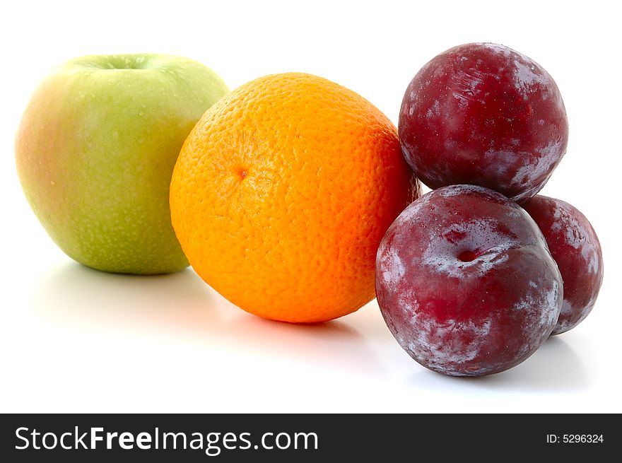 Apple, orange and  three lilac  plums on overwhite background. Apple, orange and  three lilac  plums on overwhite background.