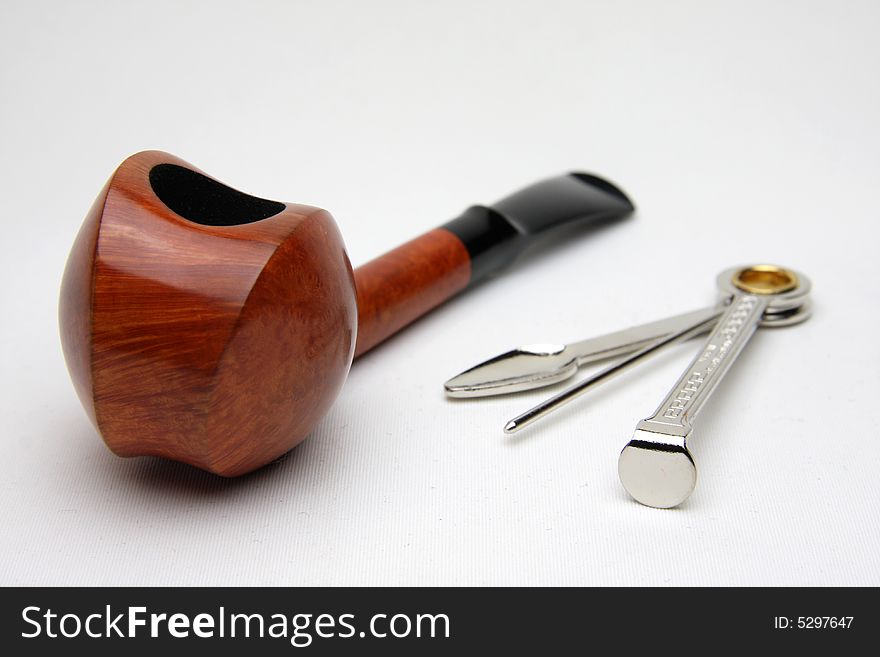 An tobacco pipe and tool isolated on white background.