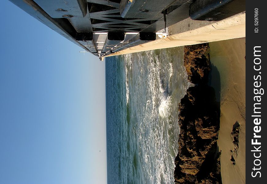 Pier at the beach with a black hand rail. Pier at the beach with a black hand rail