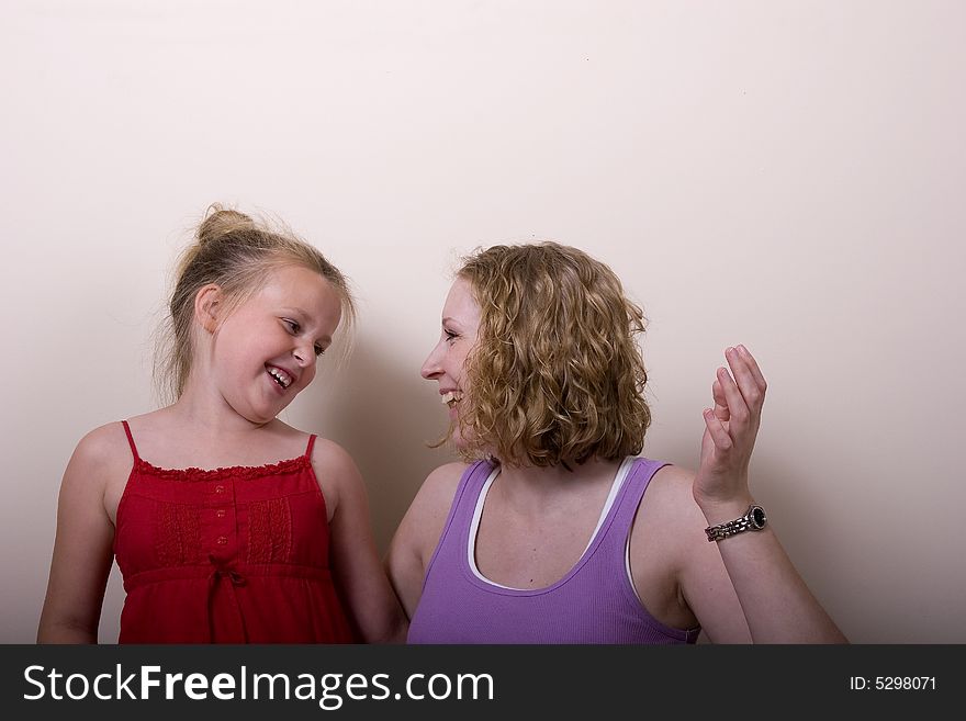 A young woman and young girl laughing and playing. A young woman and young girl laughing and playing