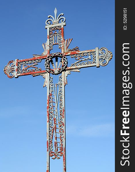 Old forged iron cross photographed in France. The blue paint is peeling. Old forged iron cross photographed in France. The blue paint is peeling.