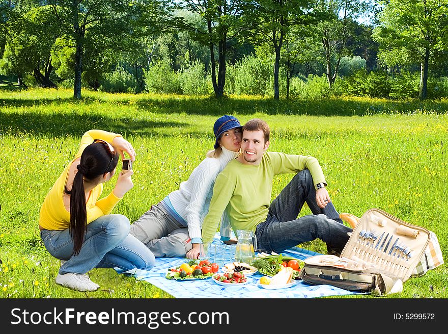Three friends at picnic making a photos
