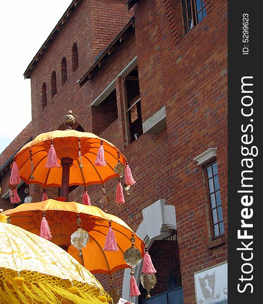 Eastern Umbrella's against a red brick building.