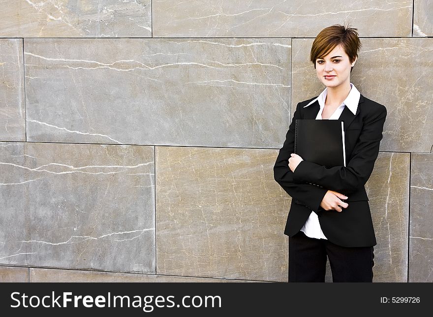 Smiling businesswoman posing on the wall. Smiling businesswoman posing on the wall