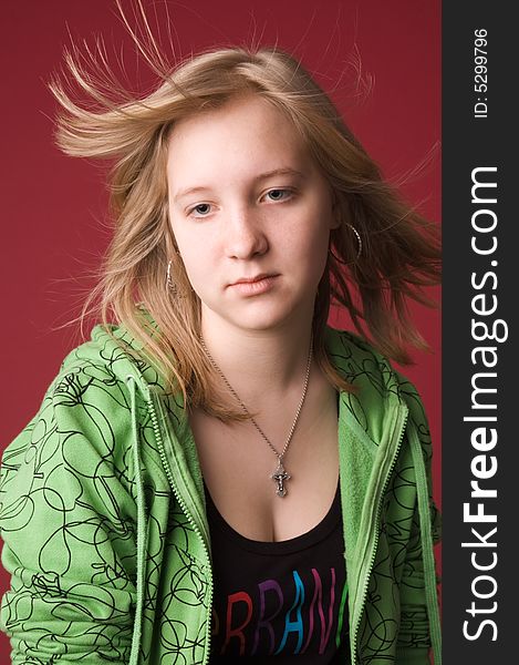 The young girl in green clothes on a red background. The young girl in green clothes on a red background.