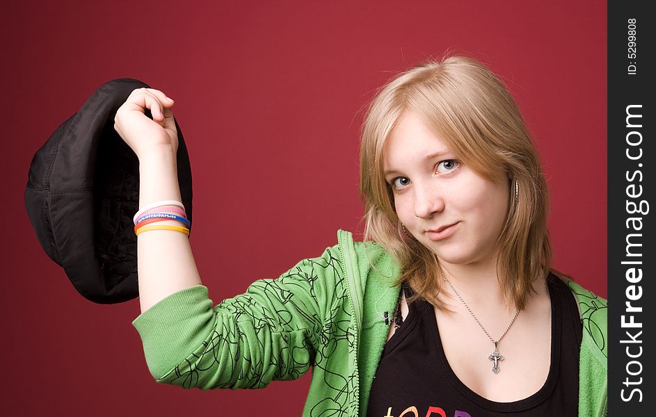 The young girl in green clothes on a red background. The young girl in green clothes on a red background.