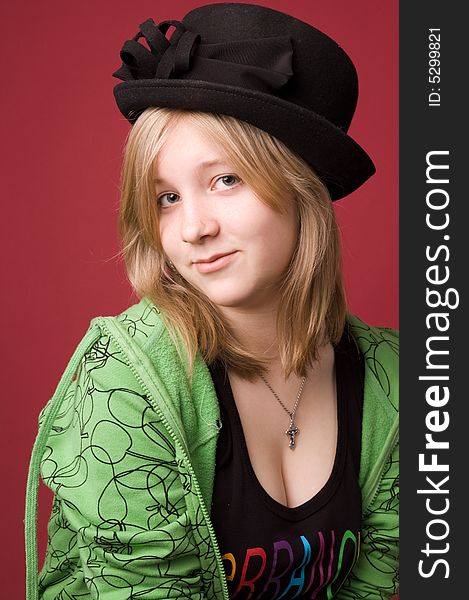 The young girl in green clothes on a red background. The young girl in green clothes on a red background.