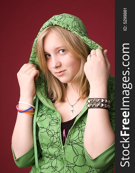 The young girl in green clothes on a red background. The young girl in green clothes on a red background.