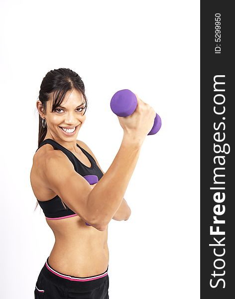 Beautiful brunette woman exercising with purple dumbbells