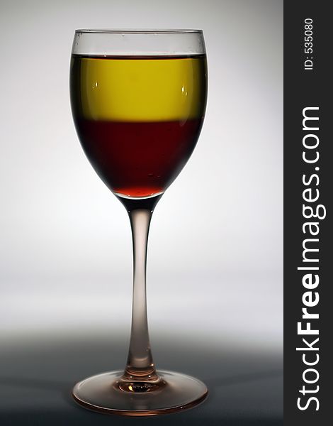 A glass of wine with white and red wines in it. A glass of wine with white and red wines in it.