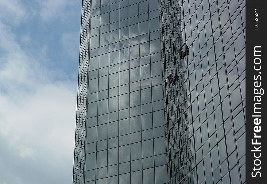 Window washers on a skyscraper. Window washers on a skyscraper