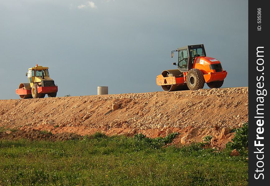 Road rollers in single file working in a new higway