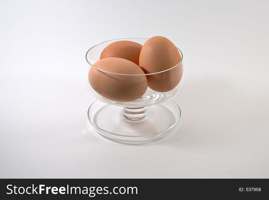 Fresh eggs in glass dish and white background. Fresh eggs in glass dish and white background