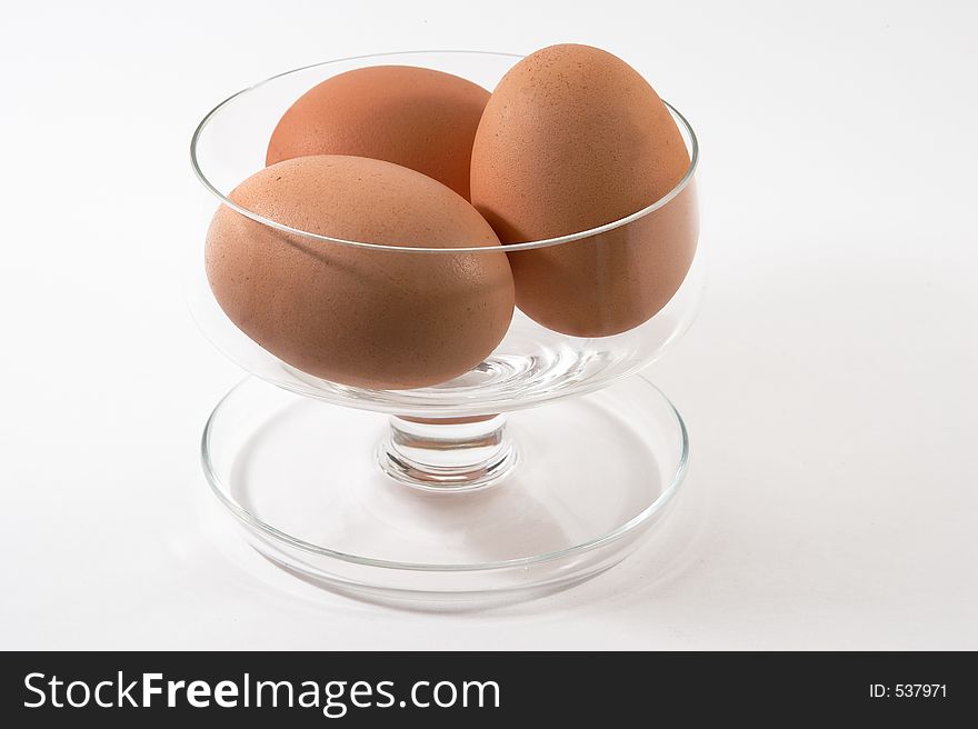 Eggs in a glass sundae dish on a white background. Eggs in a glass sundae dish on a white background