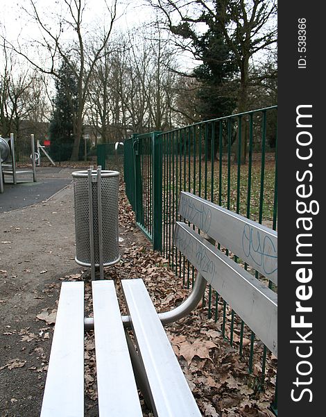 Silver bench and bin in playground. Silver bench and bin in playground