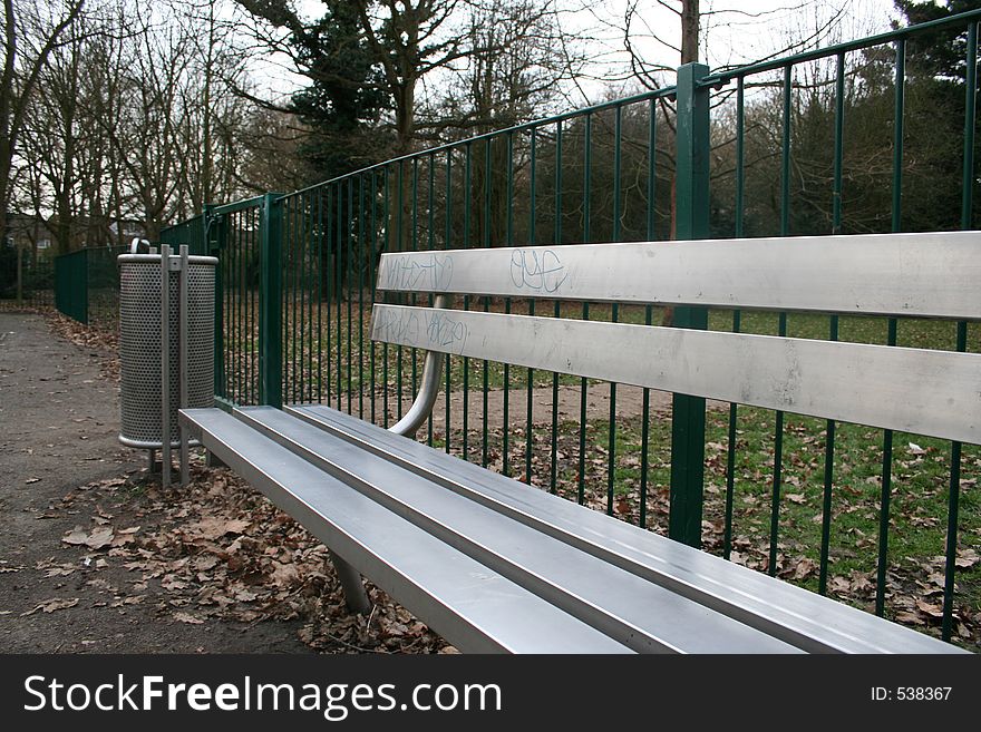 Silver bench and bin in playground. Silver bench and bin in playground