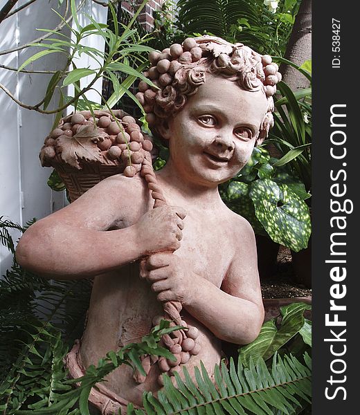 Terra cotta sculpture of a boy with grapes. Terra cotta sculpture of a boy with grapes
