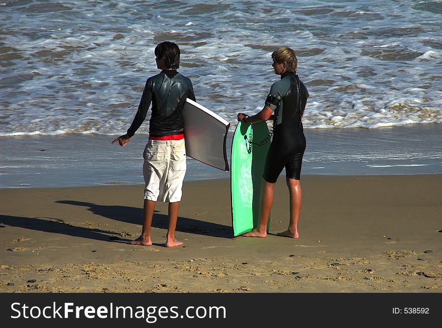 Two young boys with their boards ready to head out to the surf. Two young boys with their boards ready to head out to the surf