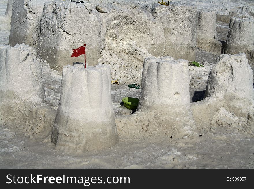 Sandcastle with red plastic flag. Sandcastle with red plastic flag