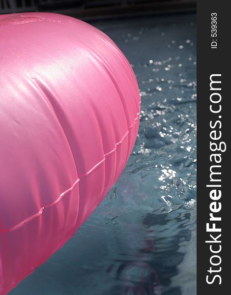 Hot pink inner tube in left of pool. Hot pink inner tube in left of pool