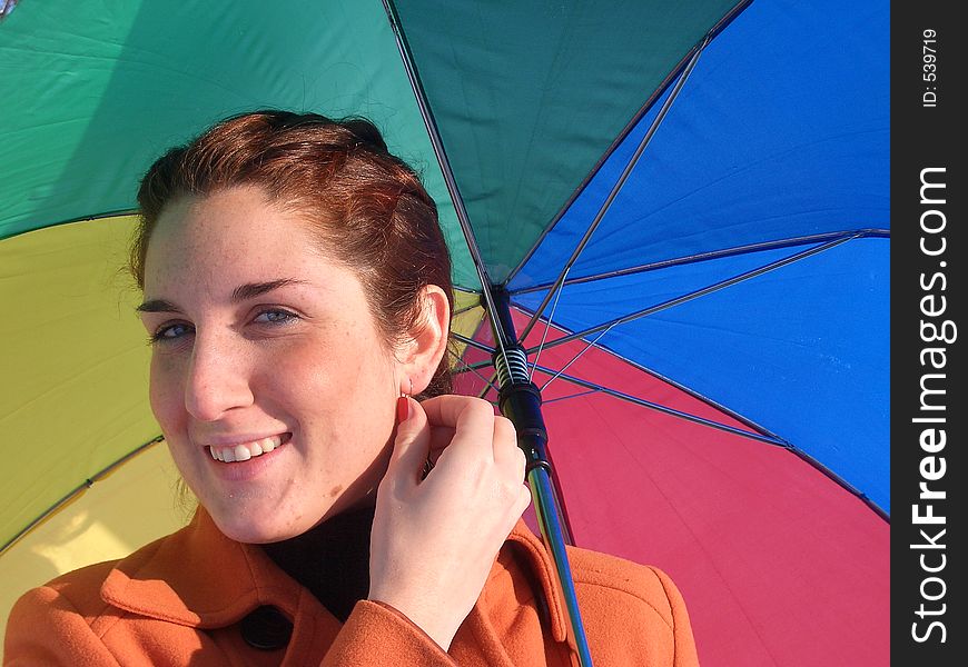 Smiling girl with a rainbow umbrella. Smiling girl with a rainbow umbrella