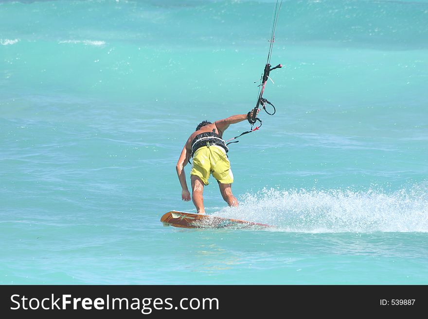 Kite surfer rides backwards with style. Kite surfer rides backwards with style.