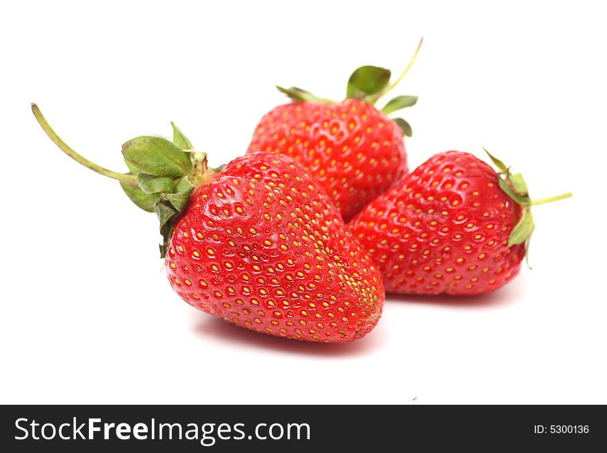 Three berry of a strawberry with foliage