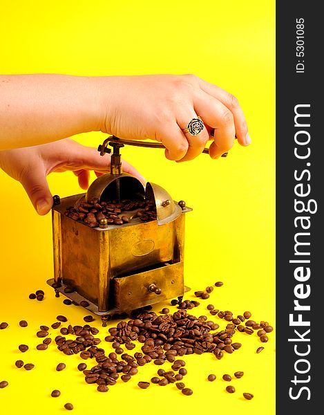 Antiquity coffee machine with beans over yellow background