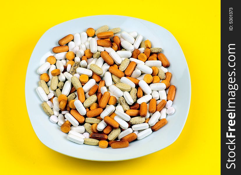 A view with some drugs and vitamins in a plate. A view with some drugs and vitamins in a plate