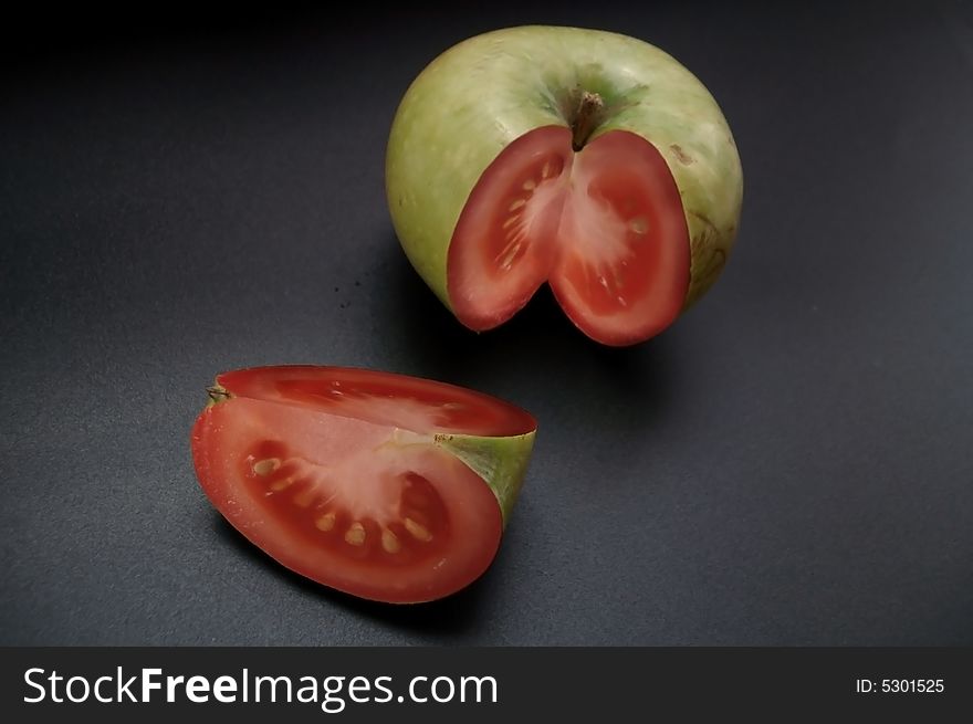 Apple-tomato art red and green colors at black background