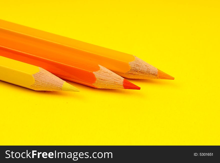 Thick colored pencils against a yellow background