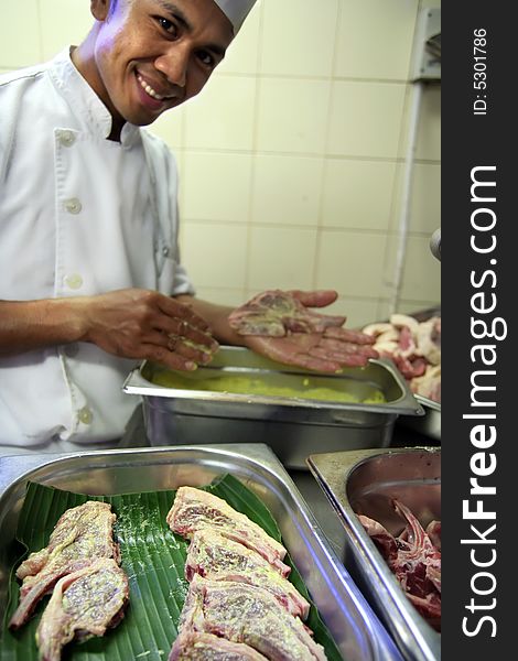 Chef in butcher butchering meat