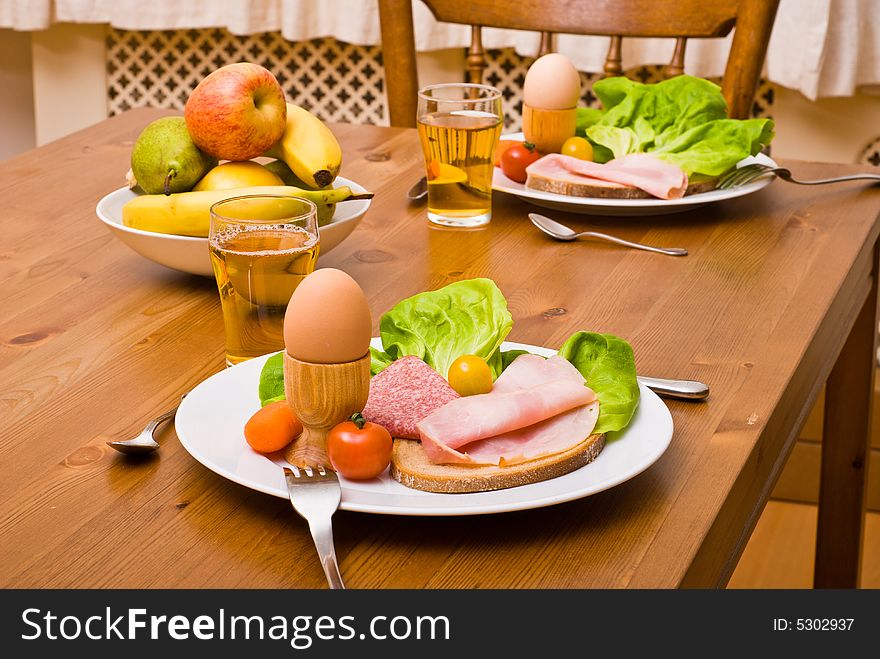Table served with snacks. Fruits, vegetables, bread, egg, ham etc. Table served with snacks. Fruits, vegetables, bread, egg, ham etc.