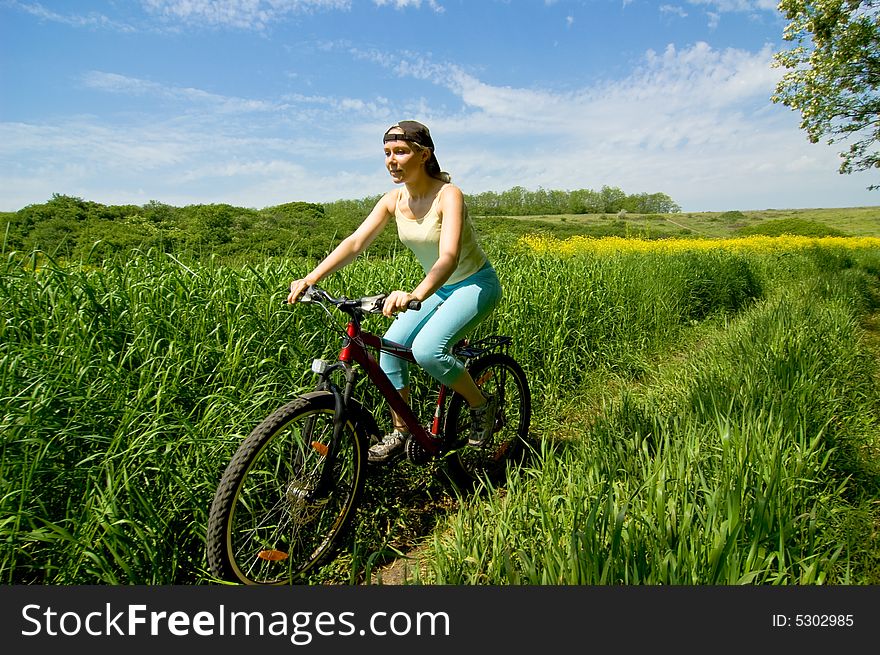 Girl biking in summer field