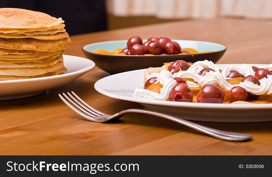 Pancakes served with fruits and whipped cream. Pancakes served with fruits and whipped cream.