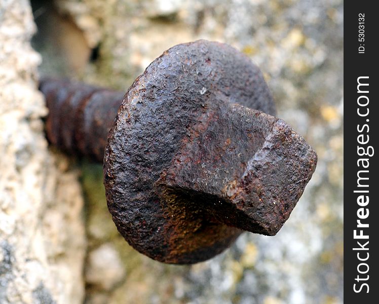 Shot of a rusty bolt in concrete