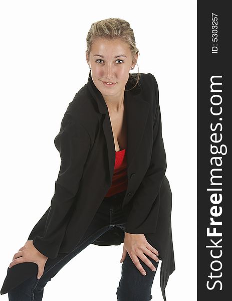 Young blond girl look direct to front with hands on knees dress in jeans with red top and black jacket. Young blond girl look direct to front with hands on knees dress in jeans with red top and black jacket