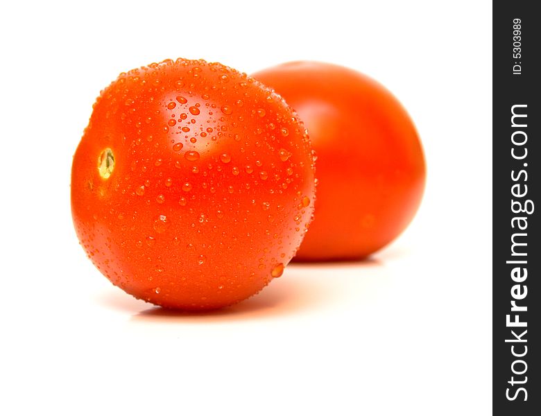 The ripe tomatoes covered by drops of water is isolated on white