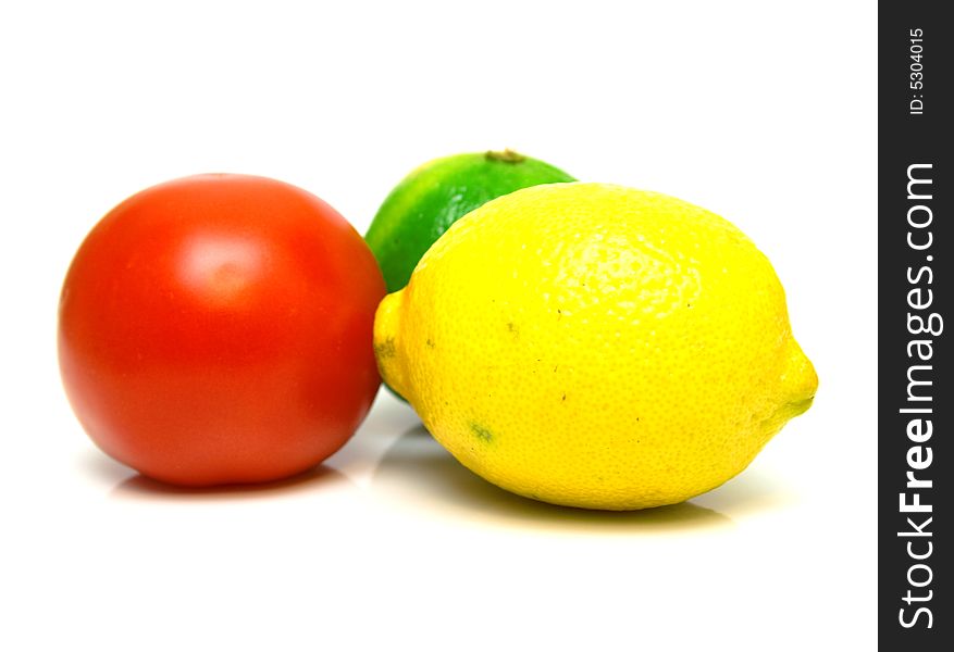 Red tomato, green lime and yellow lemon on the white background. Isolated. Shallow DOF. Red tomato, green lime and yellow lemon on the white background. Isolated. Shallow DOF.