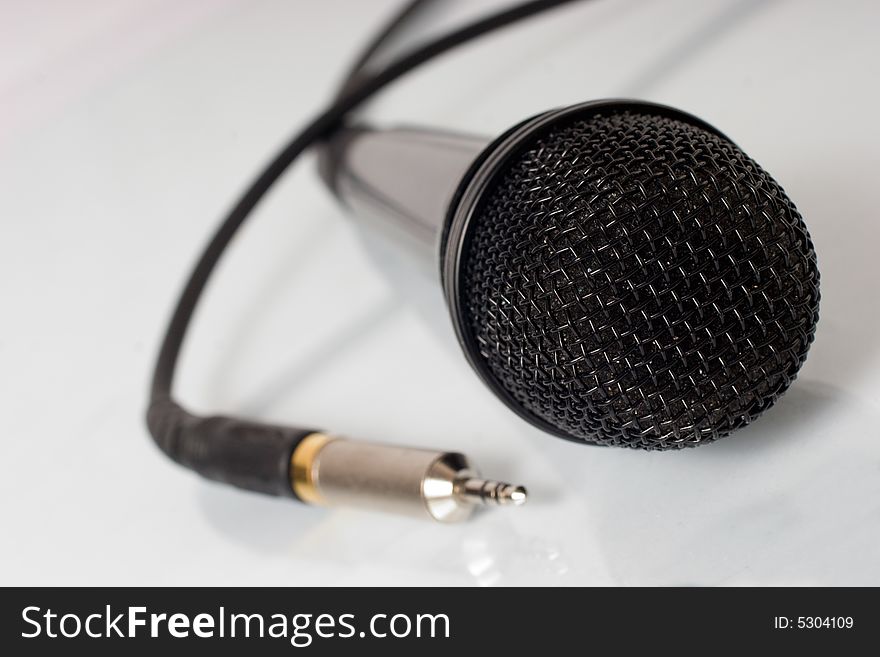 Black microphone with cable and reflection