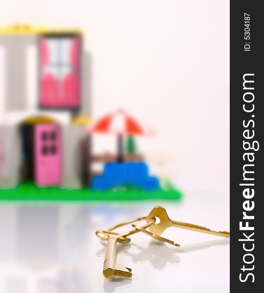 Golden key and toy house on background