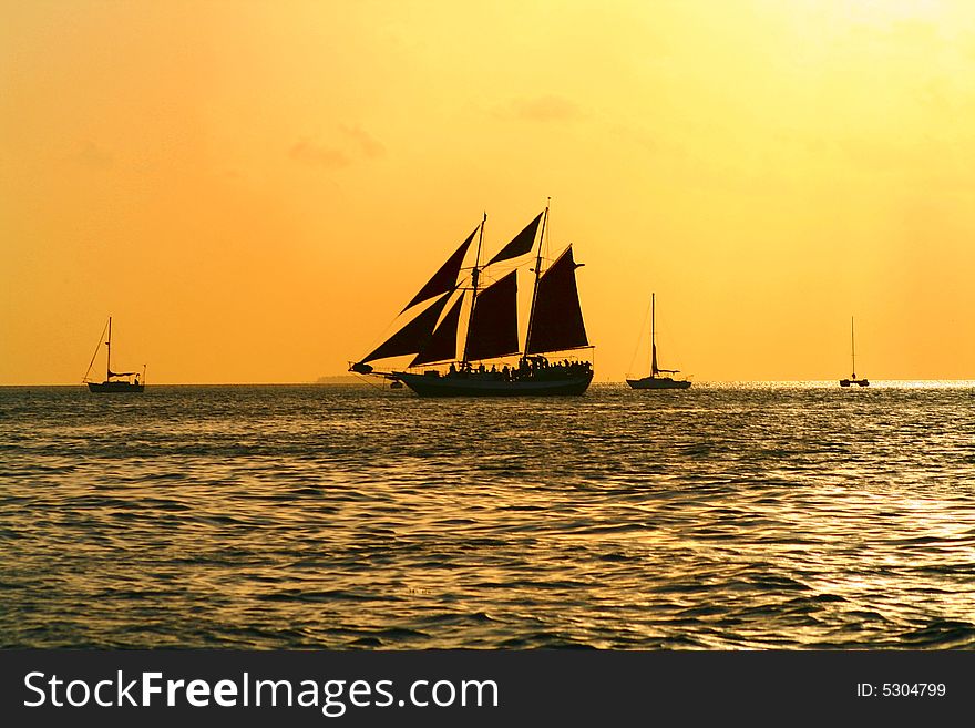 A Sailboat crosses the horizon under the evening sky. A Sailboat crosses the horizon under the evening sky.