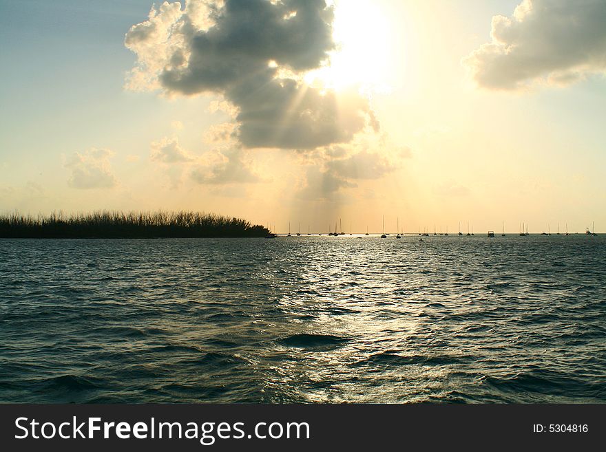 Silhouettes of boats in the distance.