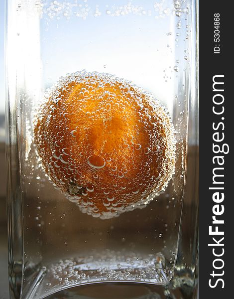 Tangerine in water with bubbles in a glass vase. Tangerine in water with bubbles in a glass vase