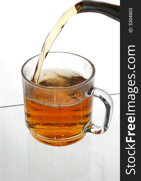 Pouring tea into glassy tea cup. Pouring tea into glassy tea cup