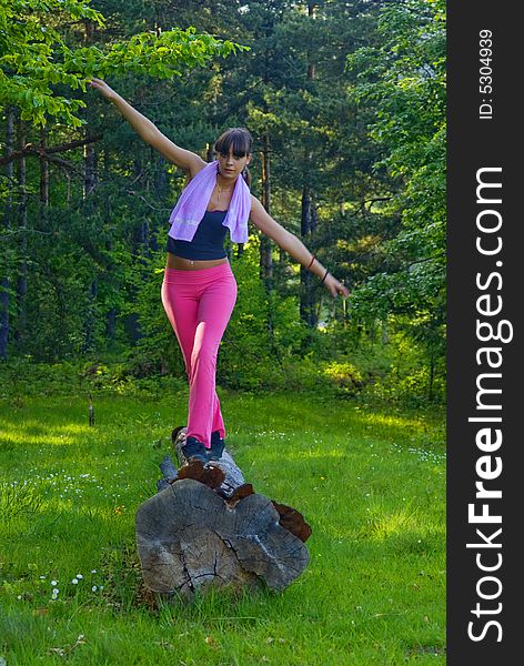 Young girl doing gymnastics in the nature with towel around neck. Young girl doing gymnastics in the nature with towel around neck